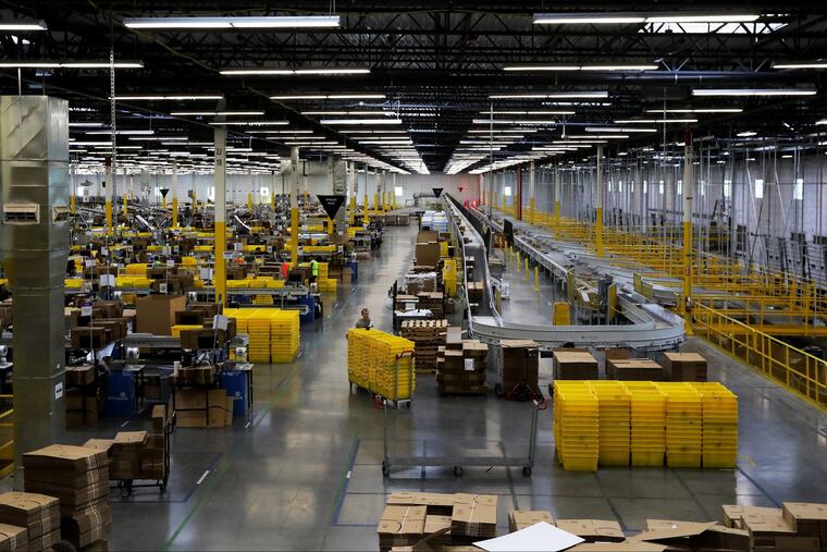 Amazon's immense multi-level warehouse called a fulfillment center in Kent, Wash. After Amazon announced its new $15-an-hour wage floor, some longtime workers said their total compensation would shrink because of the elimination of stock grants and bonuses.