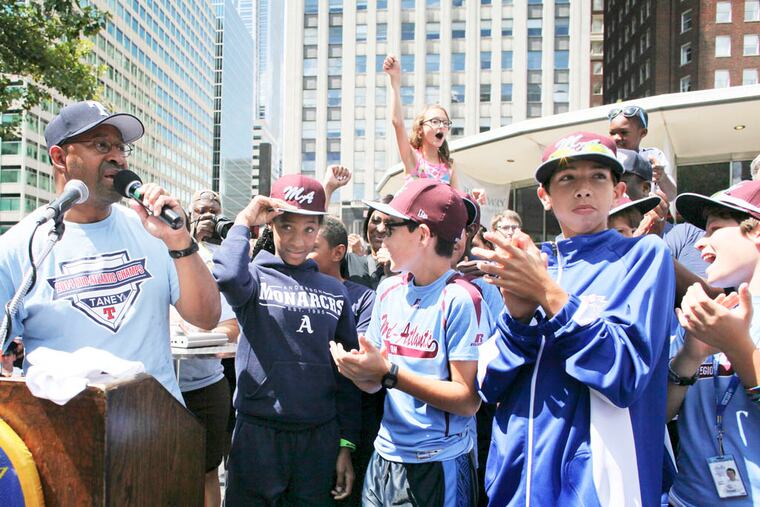 Philadelphia Mayor Michael Nutter, left, introduces members of the Taney Dragons as they are greeted by fans and city officials during a rally to celebrate the team's return to Philadelphia after competing in the Little League World Series. (AP Photo/Joseph Kaczmarek)