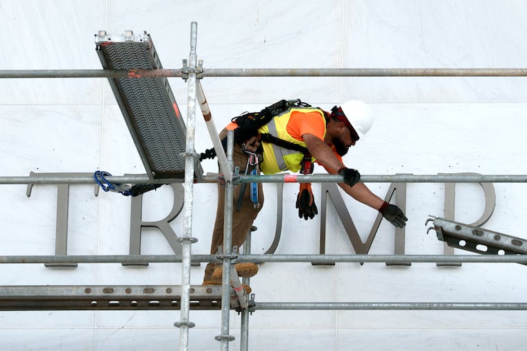 A worker constructs scaffolding in front of the John F. Kennedy Center for the Performing Arts sign in June.