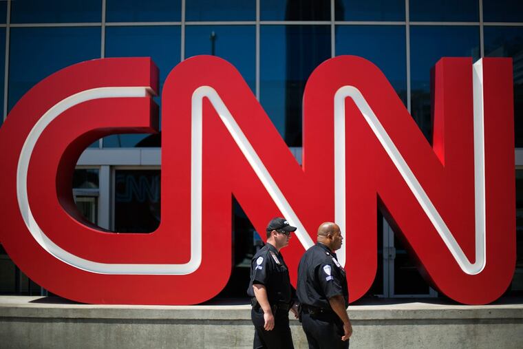 Security guards walk outside CNN’s headquarters in Atlanta.