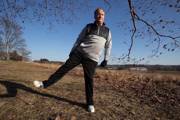 Robert Olseski , who had his right hip replaced 6 weeks ago, does some exercises in Valley Forge National Historical Park on March 3, 2021.