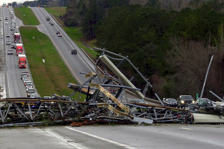 A fallen cell tower lies across U.S. Route 280 highway in Lee County, Ala., in the Smiths Station community after what appeared to be a tornado struck in the area Sunday, March 3, 2019. Severe storms destroyed mobile homes, snapped trees and left a trail of destruction amid weather warnings extending into Georgia, Florida and South Carolina, authorities said. (Mike Haskey/Ledger-Enquirer via AP)