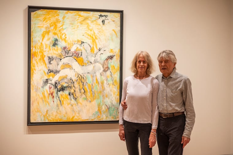 Jill and Sheldon Bonovitz, pose for a portrait in front of “Horses” by Purvis Young, at the “Of God and Country” gallery that they have collected to be displayed in the Philadelphia Museum of Art in Philadelphia, Pa., on Wednesday, June 21, 2023.