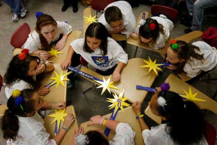 Janae Isaacs (center), 11, captain of the Stella Stars from Stella Maris Elementary School, discusses a question with teammates at the Philadelphia Reading Olympics.