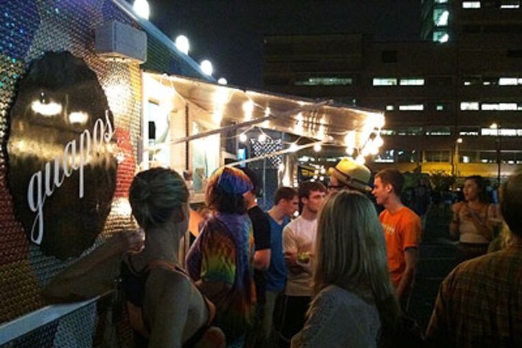 Guapos Tacos, a Jose Garces gourmet food cart, drew quite a crowd despite Thursday night's downpour. (Phillip Lucas / Staff)