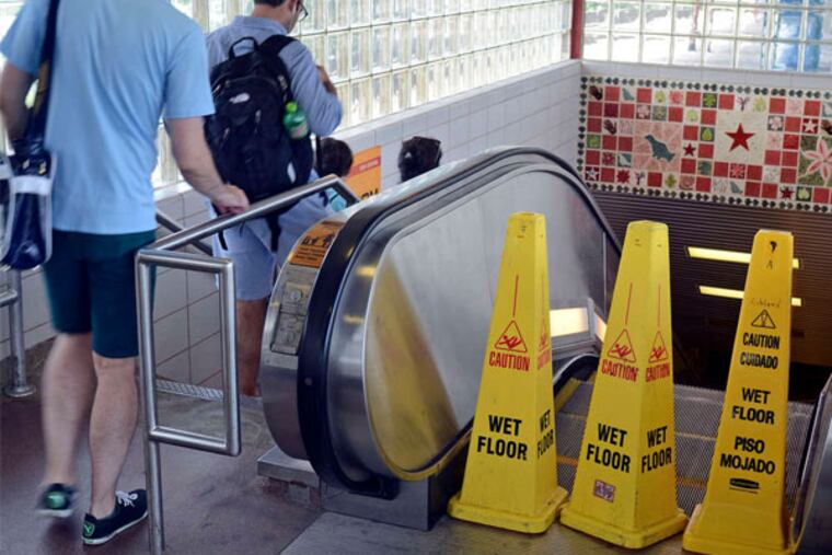 Riders descend the stairs next to an out-of-service escalator recently at the Ashland station. Escalators were back in service there Monday, as well as at the Westmont, Collingswood, and Broadway stations.
