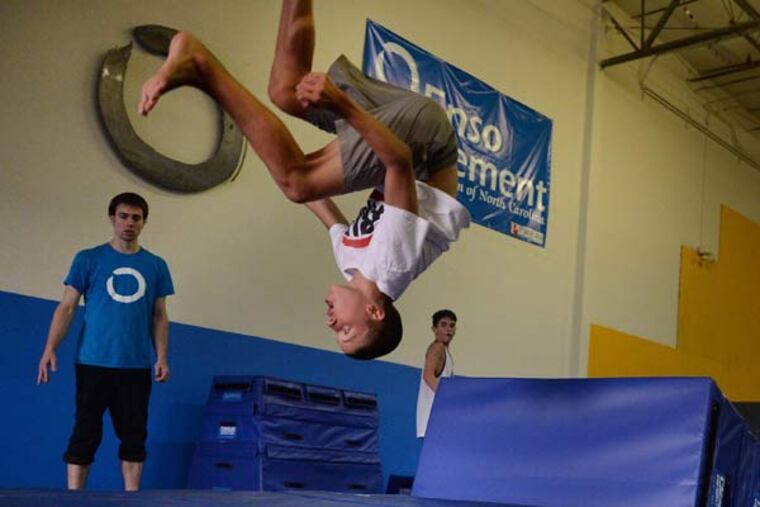 Jacob Wells, 14, does a flip during a Parkour workout in Raleigh, N.C., Aug. 7, 2014. Parkour is a holistic training discipline using movement that developed from military obstacle course training. Practitioners aim to get from A to B in the most efficient way possible. (Chuck Liddy/Raleigh News & Observer/MCT)