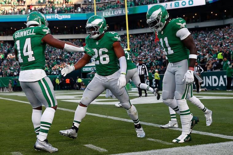Philadelphia Eagles running back Saquon Barkley (center) celebrates with teammates Kenneth Gainwell (left) and A.J. Brown (right) after Barkley scores during the first quarter against the Jacksonville Jaguars at Lincoln Financial Field on Sunday, Nov. 3, 2024, in Philadelphia.