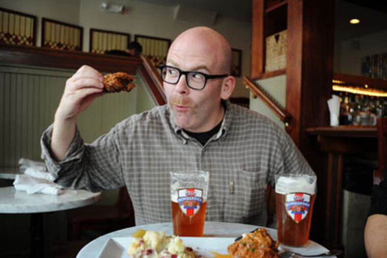 Resurrection Ale House owner Brendan Hartranft serves twice-fried chicken with potato salad and honey. (SARAH J. GLOVER / Staff Photographer)