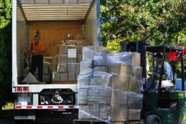 Workers load boxes containing about 80,000 cans of Silly String from a warehouse in Deptford.