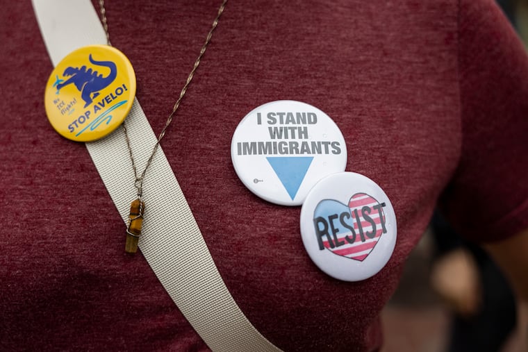 Caitlin Santos, of Willow Grove, Pa., Cochair with Montgomery County PA and Friends Indivisible, wearing pins to show their support for immigrants and the community during a rally in Norristown, Pa., on Saturday, June 7, 2025.