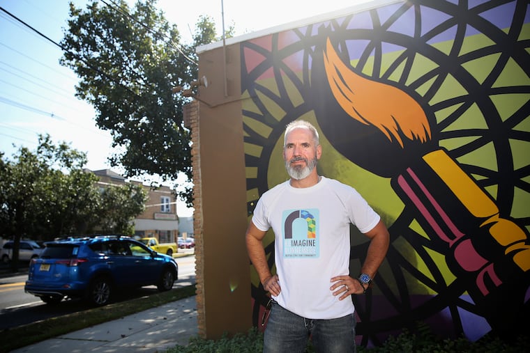 Artist J. Kenneth Leap stands for a portrait next to a mural he painted outside his studio along the Black Horse Pike in Runnemede, N.J., on Wednesday, Oct. 2, 2019.