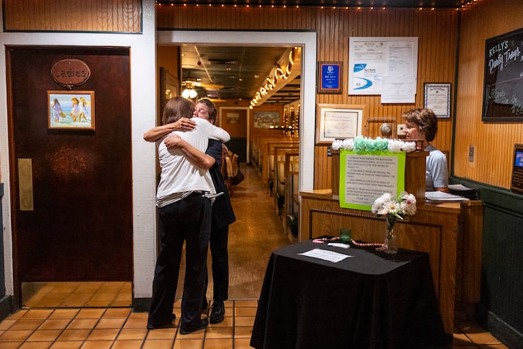 Server Chris Brown (in black uniform) hugs one of her regulars at Kelly's in Northeast Philadelphia.