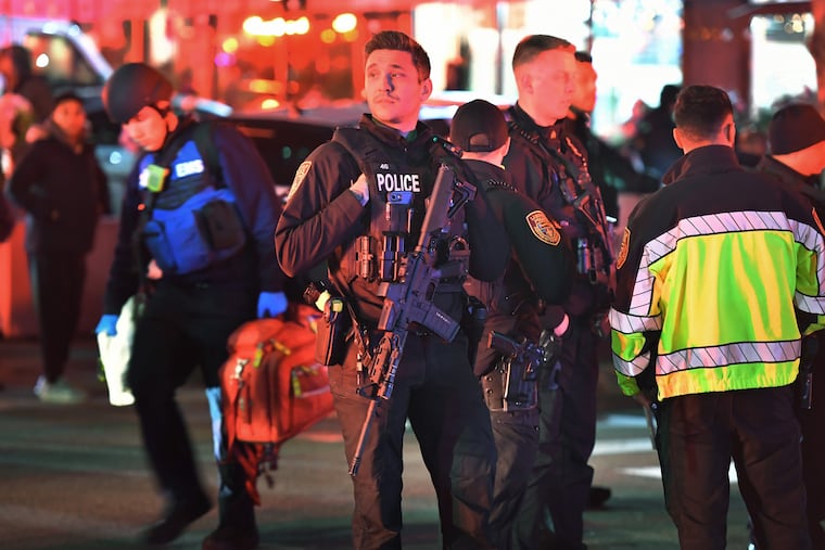 Law enforcement officials carrying weapons gather near Brown University in Providence, R.I., on Saturday, during the investigation of a shooting.