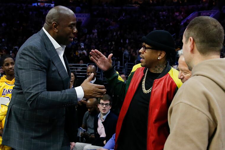 Allen Iverson (right) greats Magic Johnson during Sunday's star-studded game.