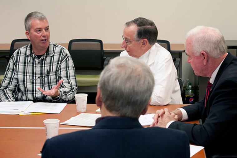 Terry Sullivan (far left) tells his story about the Affordable Care Act to Congressman Patrick Meehan (far right) as he meets with constituents in his Springfield Deco congressional offices on Nov. 6, 2013. (RON TARVER / Staff Photographer)
