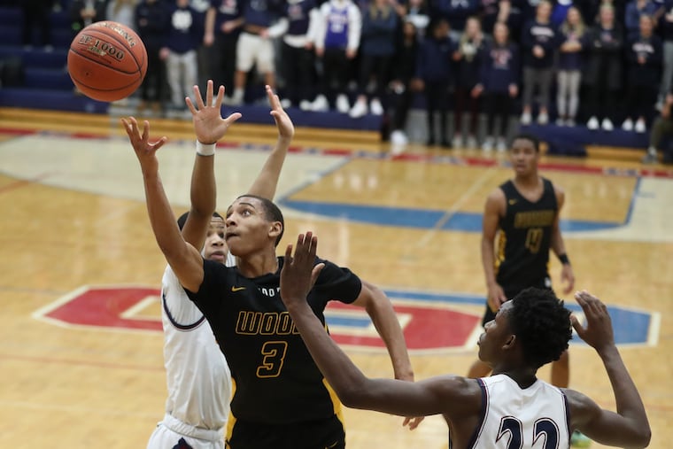 Rahsool Diggins, center, of Archbishop Wood goes up for a basket against Jameel Burton, left, and Solo Bambara, right, of Cardinal O’Hara in January.