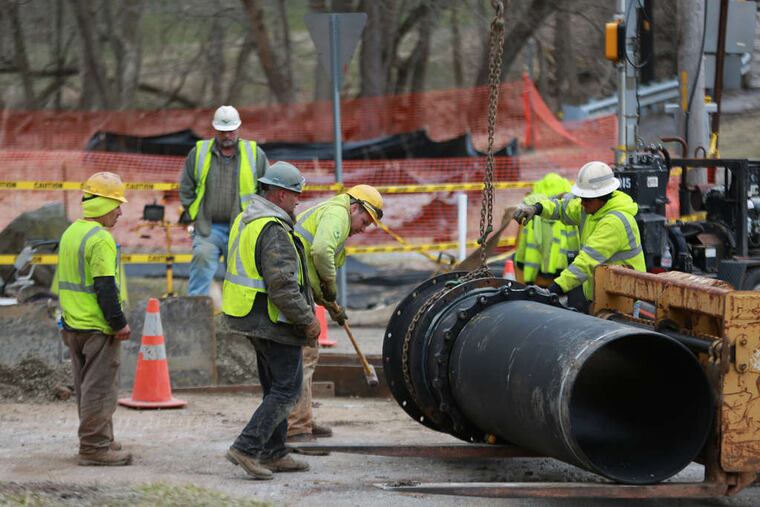 Pipefitters replacing sections of the sewage line that burst at the intersection of Routes 23 and 252 in Valley Forge Park on March 17, spilling an estimated 6.5 million gallons of raw sewage into Valley Creek.