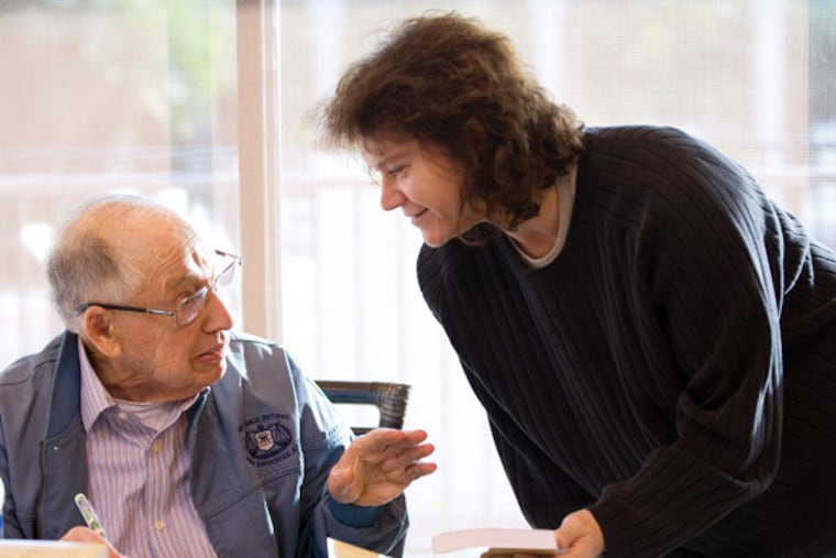 Jay Cooper, 86, signs his new novel, Hammurabi's Dagger, for friend Laura Muller of Huntington Beach, California. (Mindy Schauer/Orange County Register/MCT)