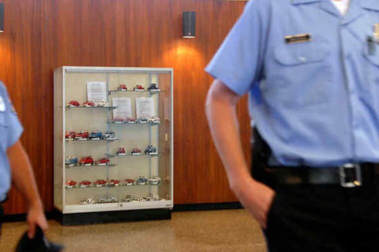 Models of Philadelphia police cars throughout the years are displayed in a case in the lobbyof Police Headquarters, above. Below right, detail of cars from 1940 and '36 (top shelf).