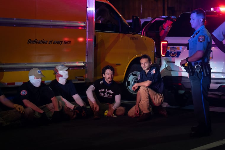 Members of the Patriot Front, a white supremacist group, are detained by police on Delaware Avenue in July 2021.