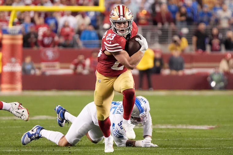 San Francisco 49ers running back Christian McCaffrey runs in front of Detroit Lions defensive end Romeo Okwara.