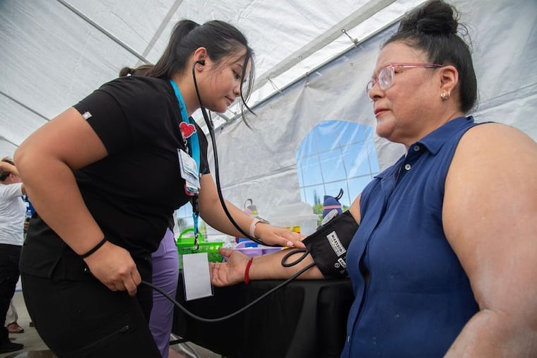 Nurse Haley Delgado, left, takes Maria Hernandez's blood pressure at the Community Medical Center's Health and Resource Fair at Banner Island Ballpark in downtown Stockton, California, on Aug. 9, 2025.