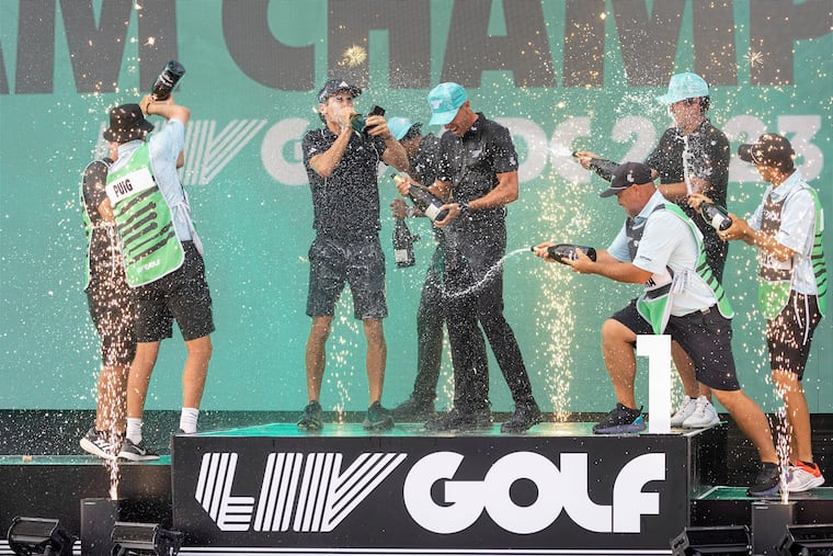 Team champions David Puig, Sebastián Muñoz, Mito Pereira, Captain Joaquín Niemann of Torque GC and their caddies celebrate on stage with the team trophy during LIV Golf DC at the Trump National Golf Club in Washington Sunday, May 28, 2023, in Sterling, Virginia.(Photo by Chris Trotman/LIV Golf via AP, File)