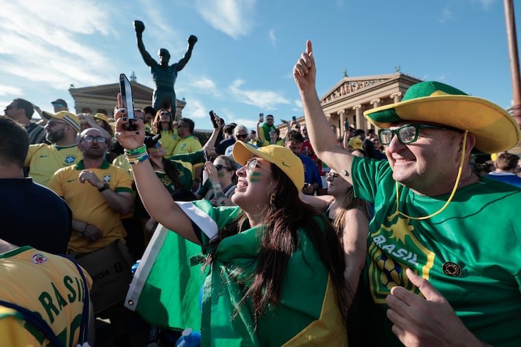 Brazil fans Camila Smith and Joao Vicente Peixoto gather with fellow fans at the Art Museum steps for a rally on Thursday.