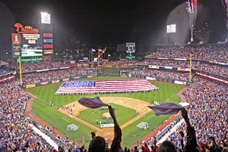 Fans cheer on the national anthem as Game 3 of the 2009 World Series is about to start after an hour-long delay at Citizens Bank Park. (Michael Bryant / Staff Photographer)