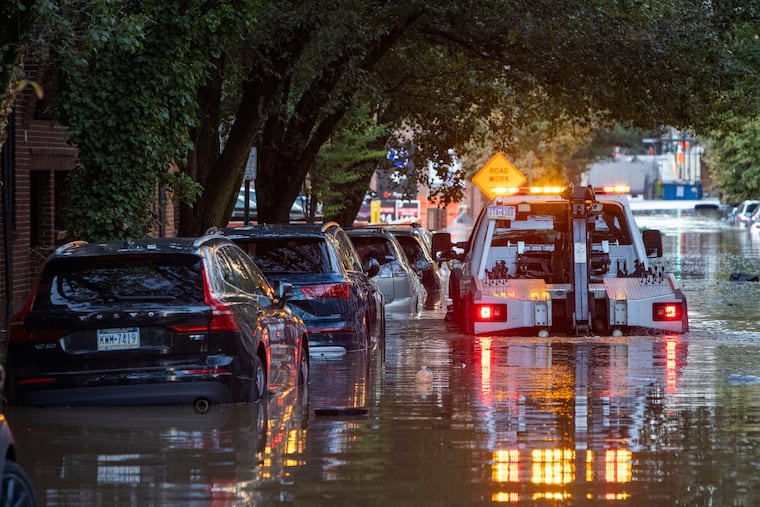 A tow truck works to remove a car from flood water on N. 23rd near Race Street on Sept. 2.