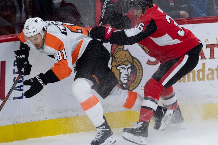 The Senators' Colin White checks the Flyers' Carsen Twarynski along the boards during the second period Friday night in Ottawa. The Flyers lost, 2-1.