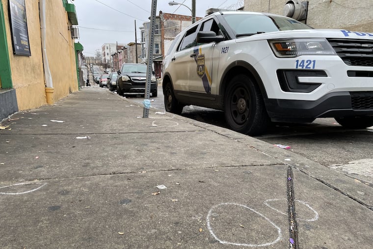 White chalk circles mark where police officers had found bullets on the 5100 block of Germantown Ave. after a shooting on Dec. 30, 2021 that left six people injured.