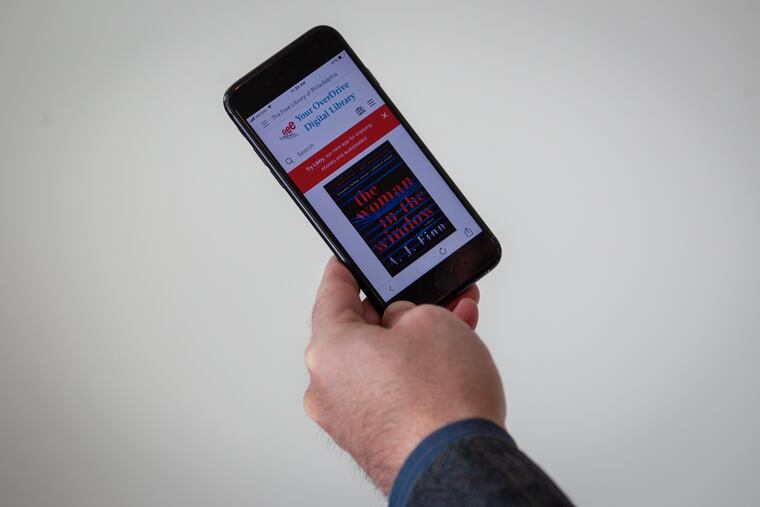 Iphone in hand of PMN reporter Bob Fernandez, in office 801 Market St. Philadelphia on Tuesday, January 15, 2018. The phone had image of ebook available for loan at the Free Library of Philadelphia. Book displayed is Woman in the Window by A.J. Finn