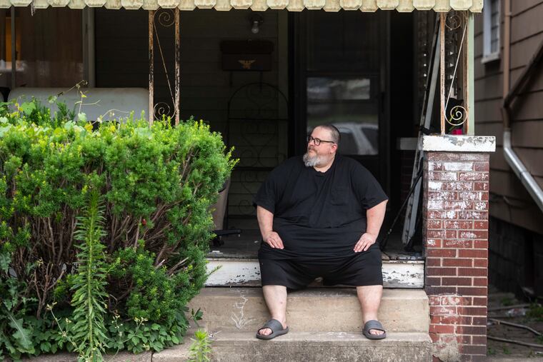 Mike Ramsey sits on the front porch of his house. Ramsey’s water was shut off for 10 weeks while he waited for help from a state program for mortgage and utility relief.
