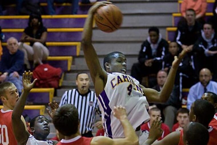 Camden’s Aaron Walton-Moss jumps to grab a rebound between teammates Takwail Bailey (left) and Tevin Solomon (right) and Lenape’s Pete Dinich. (David M. Warren / Staff Photographer)