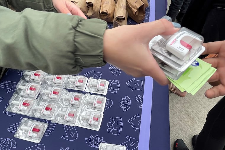 Workers and volunteers with Savage Sisters hand out Narcan as they offer outreach in McPherson Square Park in 2022 to those fighting substance abuse.