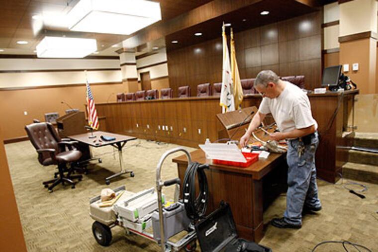 Chris Hughes finishes the audio/video wiring in the courtroom of the new Voorhees Township offices at the Voorhess Town Center, once the largest mall in South Jersey, on Friday. (Elizabeth Robertson / Staff Photographer)