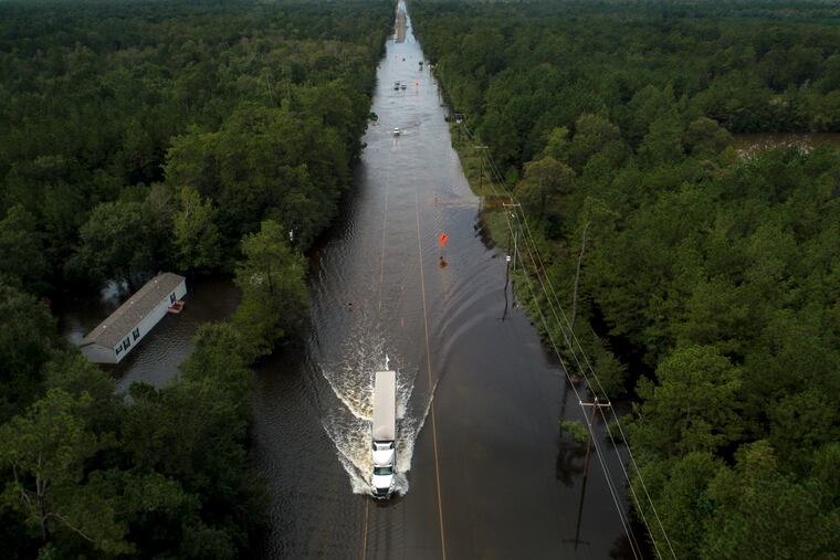 A truck drives through a flooded highway as flooding from the remnants of Tropical Storm Imelda continues in Southeast Texas on Friday, Sept. 20, 2019, in Mauriceville, Texas.