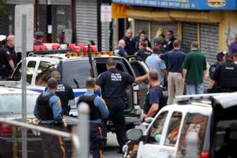Police officers in Jersey City, N.J., swarm the scene of the gunfight, which followed a stakeout of a couple sought in a robbery. Two of the five wounded officers were in critical condition.