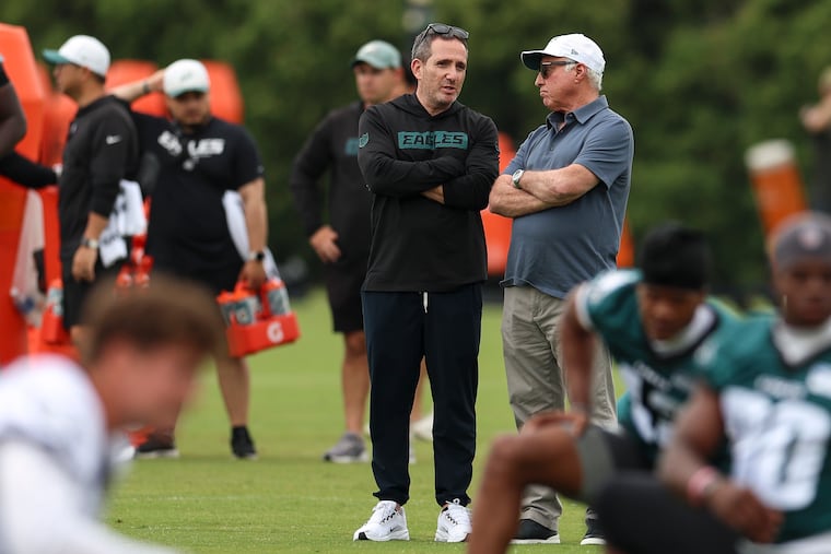 Eagles general manager Howie Roseman (left) talks with owner Jeffrey Lurie during mandatory minicamp in June.