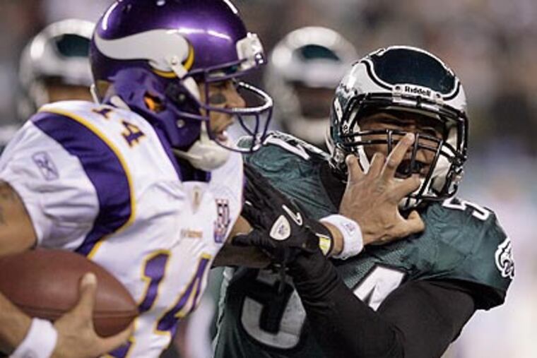 Vikings quarterback Joe Webb grabs the facemask of Jamar Chaney in the third quarter. (Yong Kim/Staff Photographer)