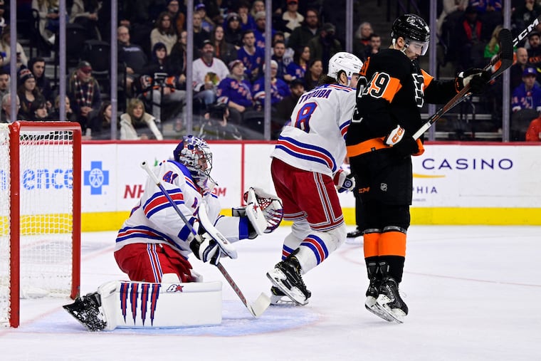 Rangers goaltender Jaroslav Halak makes a glove save past the defense of Jacob Trouba and the Flyers' Noah Cates during the Flyers' latest loss on Saturday.