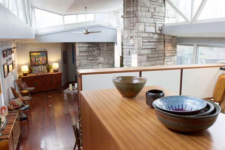 The kitchen and dining area is divided from a sitting area by a floor-to-ceiling stone fireplace. Changes to the house, which was designed in 1949, keep the original spirit. (Ed Hille / Staff Photographer)