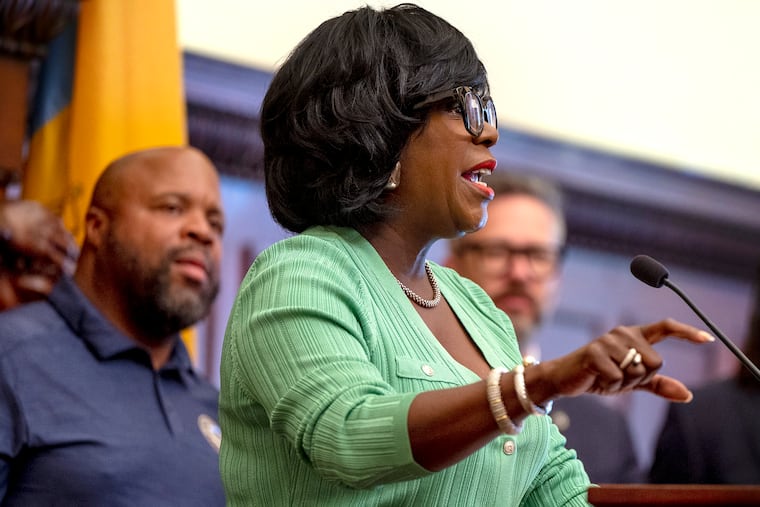 Mayor Cherelle L. Parker holds a press conference at City Hall. Behind her is Ryan Boyer (left), business manager for the Philadelphia Building and Construction Trades Council.