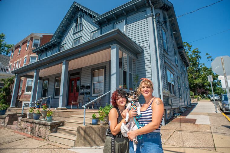 Larissa Hopwood (right), her daughter, Rowan, and their dog, Dazey, outside at their new apartment — a historic house in Doylestown that once was a general store.