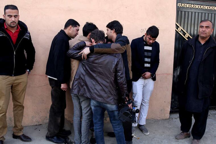 MASSOUD HOSSAINI / ASSOCIATED PRESS Afghan friends of journalist Zubair Hatami, who died in a Taliban attack, mourn at his funeral Sunday.