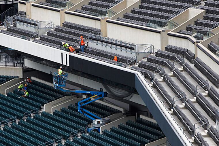 Construction Workers add LED ribbon board. (Michael S. Wirtz/Staff Photographer)