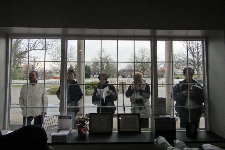 Family members pray recently outside AristaCare at Meadow Springs in Plymouth Meeting. Nursing homes have been advised to greatly restrict visitation to prevent spread of the coronavirus.