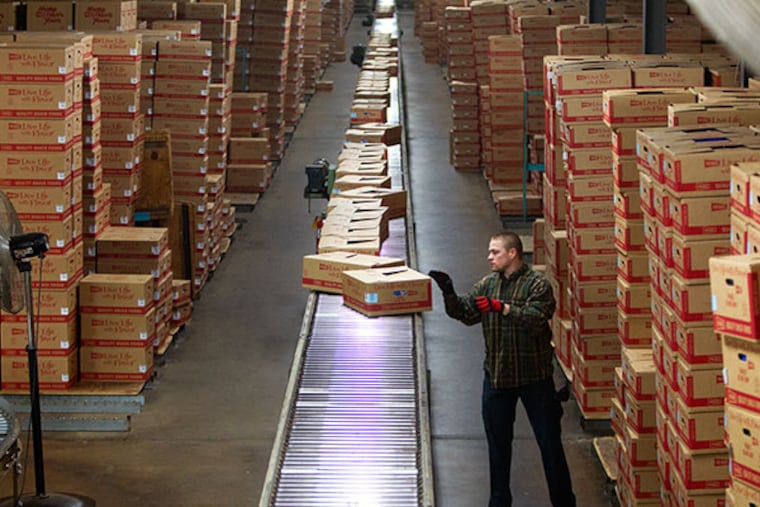It's an all out blitz as Chester County based potato chip maker Herr's prepares for Saturday's Eagle-Saints playoff game and an upcoming blizzard. Here at the Nottingham plant an unidentified worker puts boxes of chips on a conveyor belt for distribution to local stores Thursday January 2, 2014. ( ED HILLE / Staff Photographer )